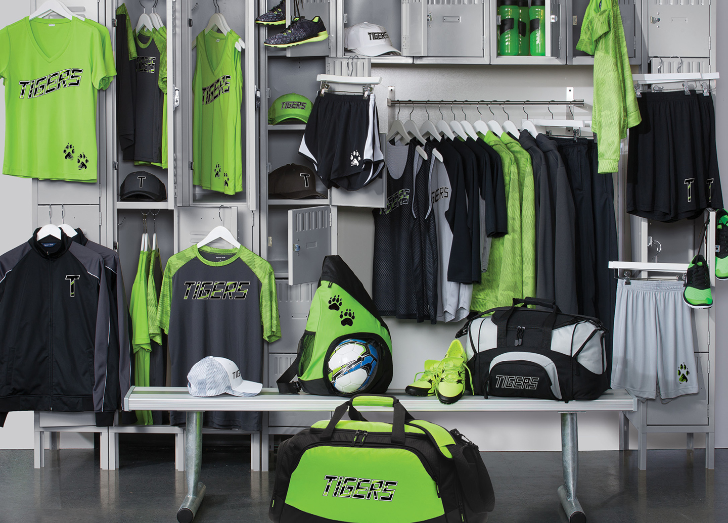 Locker room display of custom school spirit wear including t-shirts, hoodies, hats, duffel bags, and water bottles with Tigers branding, highlighting the convenience of online spirit wear stores for schools