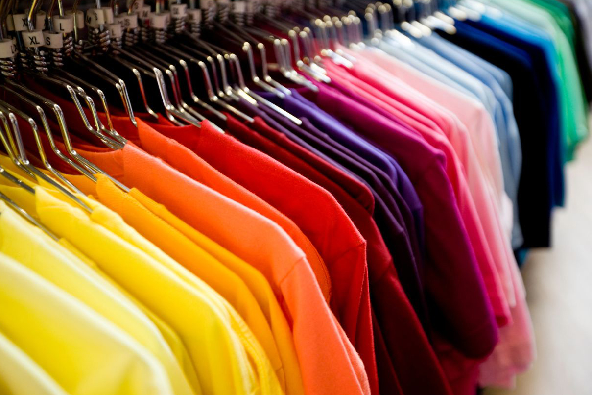 Colorful T-shirts on a rack, showcasing custom apparel choices for non-profit fundraising.