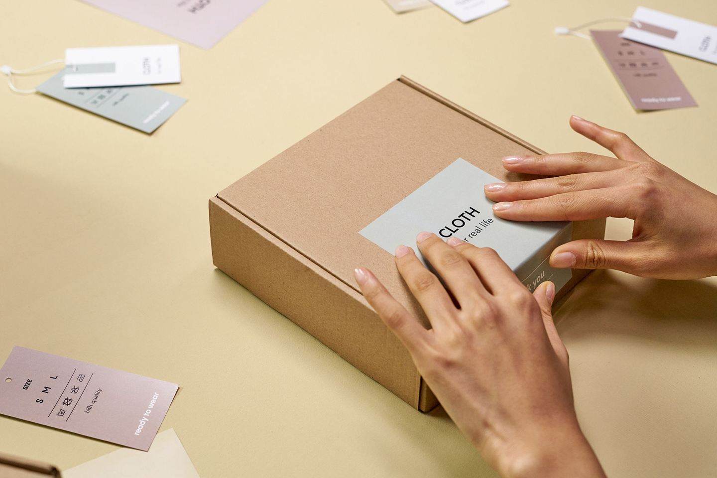 Hands packaging a custom apparel order in a shipping box, representing Zamar Inc.’s streamlined fulfillment and delivery services across Colorado.